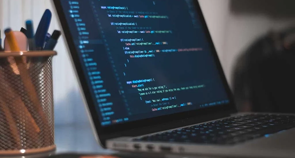 Ein Laptop, der auf seinem Bildschirm eine Reihe von Codezeilen anzeigt.
