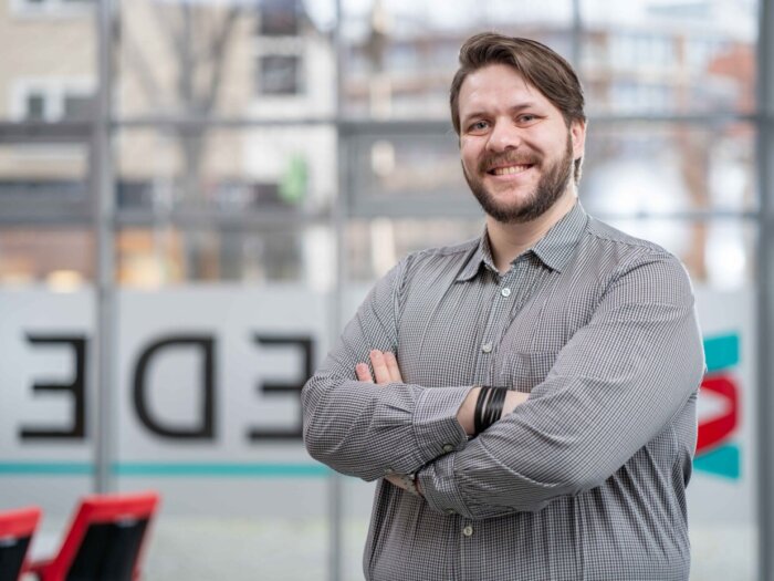 Trainer Andreas Siewert von BREDEX. Ein junger weißer Mann mit mittelbraunen kurzen Haaren und einem Bart.