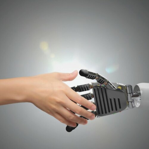 Mensch und Roboter reichen sich die Hand – Symbol für vertrauensvolle KI-Zusammenarbeit