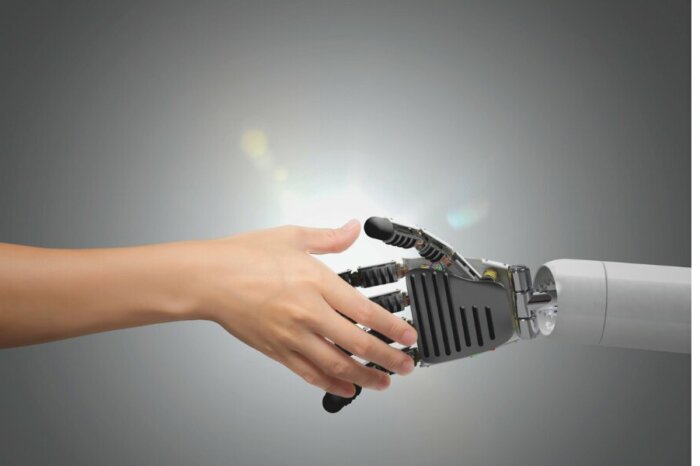 Mensch und Roboter reichen sich die Hand – Symbol für vertrauensvolle KI-Zusammenarbeit