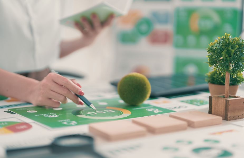 Person arbeitet mit ESG-Diagrammen und Nachhaltigkeitsdaten am Schreibtisch